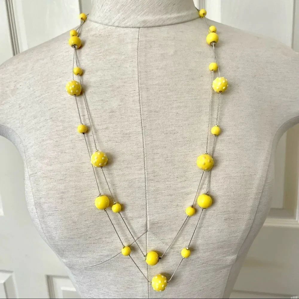 Long yellow beaded necklace on silver tone chain